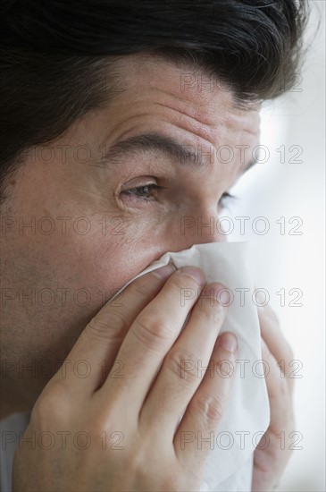 USA, New Jersey, Jersey City, Man with flu, blowing nose.