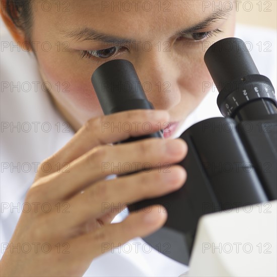 USA, New Jersey, Jersey City, Female scientist using microscope.