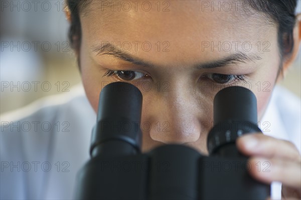 USA, New Jersey, Jersey City, Female scientist using microscope.