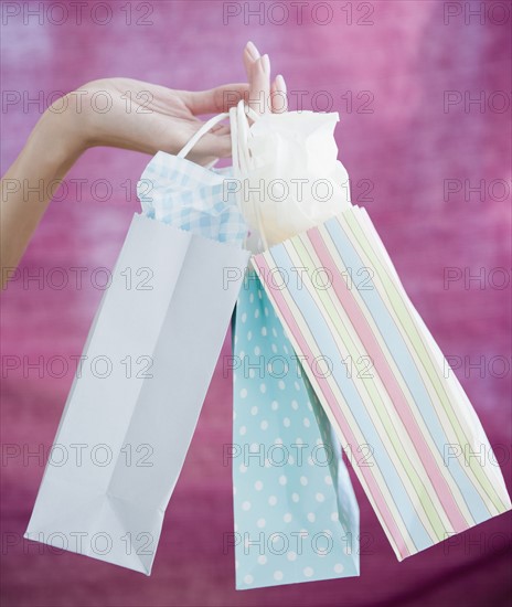 USA, New Jersey, Jersey City, Close-up view of woman's hand holding shopping bags. Photo : Jamie Grill Photography