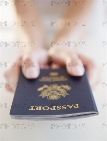 USA, New Jersey, Jersey City, Close-up view of woman's hands holding US passport. Photo : Jamie Grill Photography