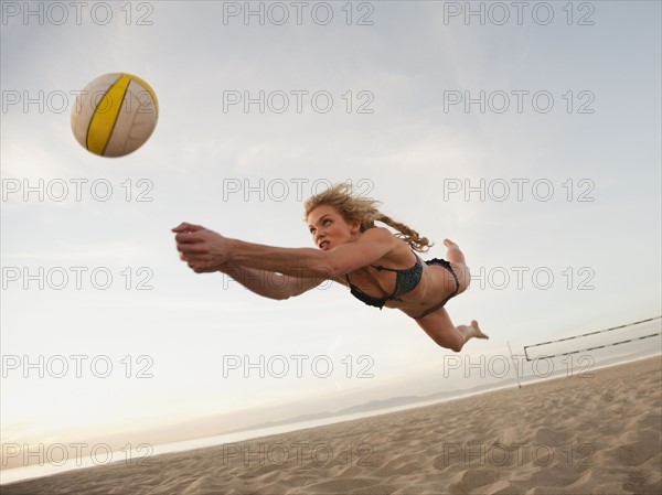USA, California, Los Angeles, woman playing beach volleyball.