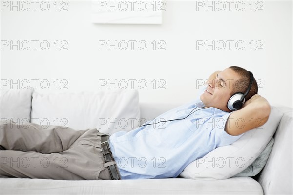South Africa, Man relaxing while listening music. Photo : momentimages
