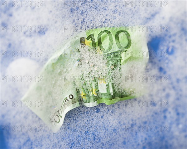 One hundred euro note soaking in soap sud. Photo : Mike Kemp