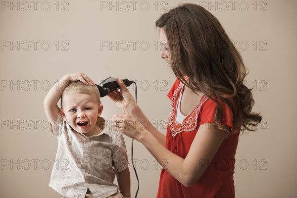 USA, Utah, Lehi, mother shaving son's (18-23 months) head. Photo : Mike Kemp