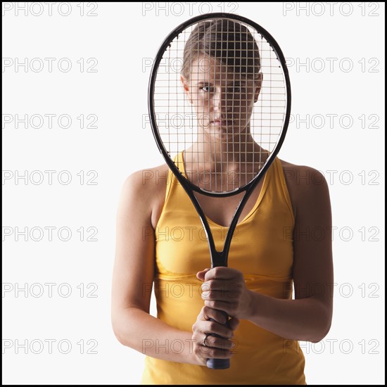 Young woman holding tennis racket. Photo : Mike Kemp