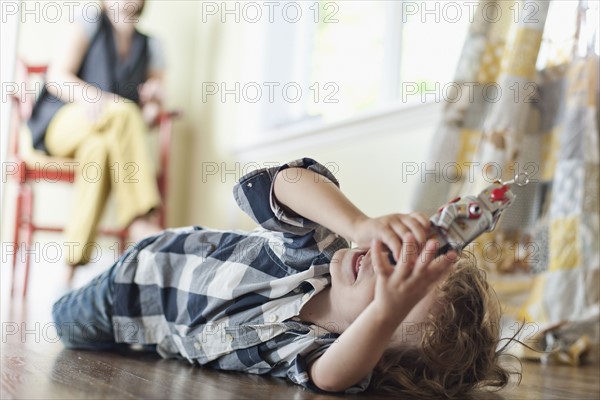 USA, Utah, Boy (2-3) playing on floor. Photo : Tim Pannell