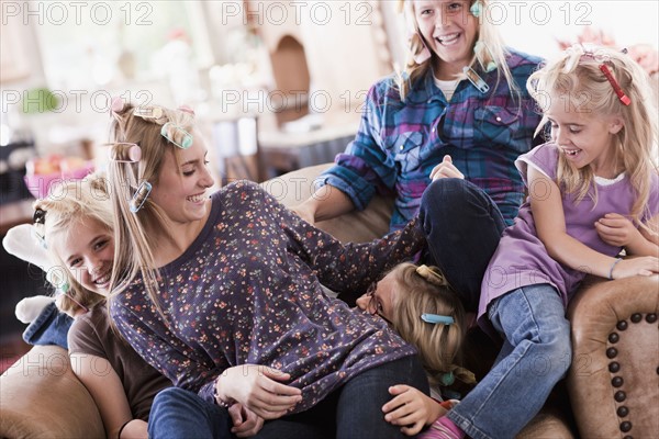 USA, Utah, family portrait of sisters (6-7, 8-9, 12-13, 14-15, 16-17) on sofa having fun. Photo : Tim Pannell