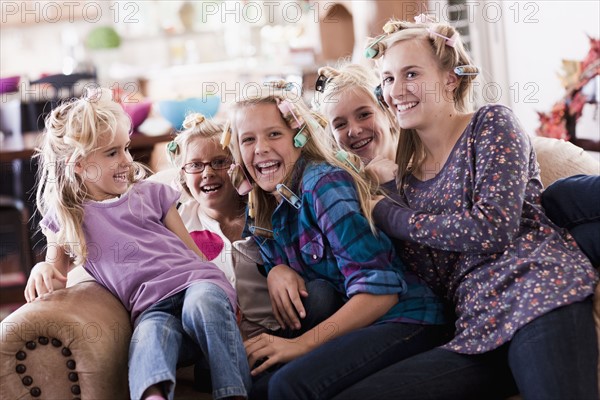 USA, Utah, family portrait of sisters (6-7, 8-9, 12-13, 14-15, 16-17) on sofa having fun. Photo : Tim Pannell