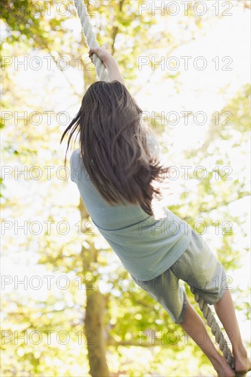 USA, Utah, rear view of girl (10-11) hanging on rope. Photo : Tim Pannell