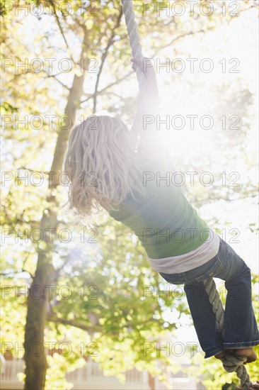 USA, Utah, rear view of girl (8-9) hanging on rope. Photo : Tim Pannell