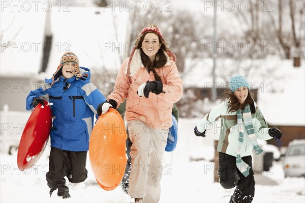 USA, Utah, Provo, Boys (10-11, 12-13) and girls (10-11, 16-17) running with sledge. Photo : FBP