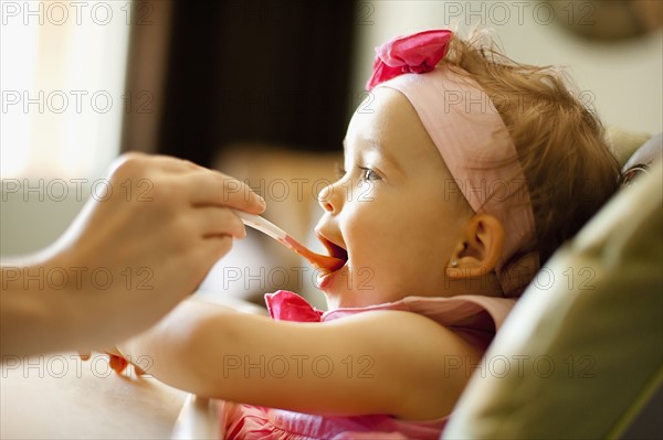 Girl (2-3) is feeding by mother. Photo : FBP