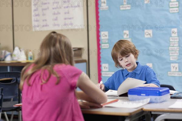 Girl (10-11) and boy (6-7) reading in classroom. Photo : Dan Bannister