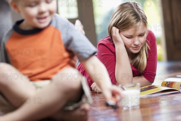 USA, Utah, Children (4-11) relaxing in home, girl reading book. Photo : Tim Pannell