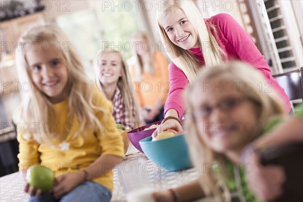 USA, Utah, family portrait of sisters (6-7, 8-9, 12-13, 14-15, 16-17) having fun at table. Photo : Tim Pannell