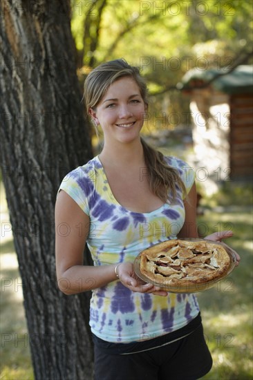 USA, Colorado, Cheerful young woman holding pie. Photo : John Kelly