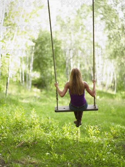 USA, Colorado, Mature woman swinging, rear view. Photo : John Kelly