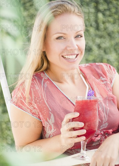 USA, New Jersey, Jersey City, Young attractive woman with pink refreshment drink. Photo : Jamie Grill Photography