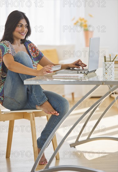 USA, New Jersey, Jersey City, Young Indian woman using laptop. Photo : Daniel Grill