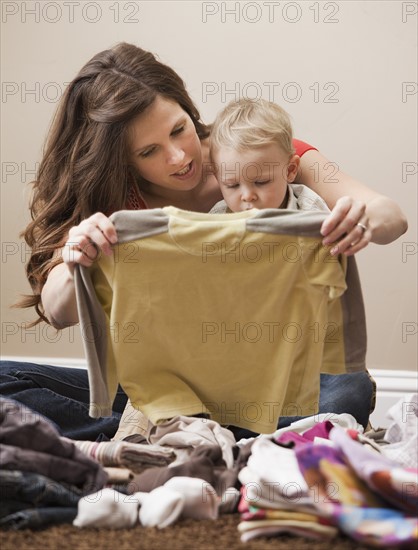 USA, Utah, Lehi, mother and son (18-23 months) folding laundry. Photo : Mike Kemp