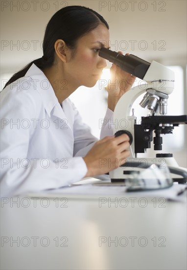 USA, New Jersey, Jersey City, Female scientist using microscope.