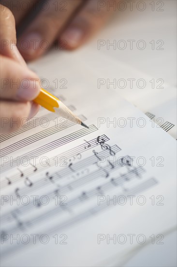 Man writing notes on sheet music.