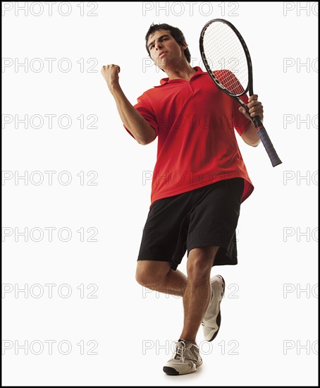 Young man playing tennis winning. Photo : Mike Kemp