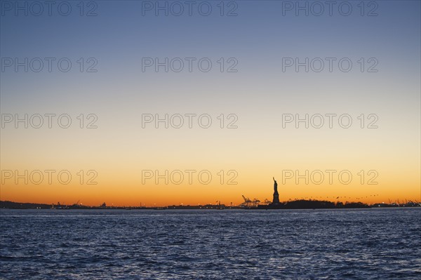 USA, New York City, Staten Island, Harbor and silhouette of Statue of Liberty in background.