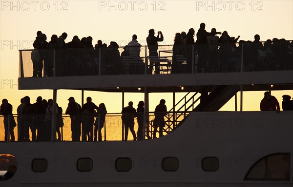 USA, New York City, Silhouette of passengers on tourboat.