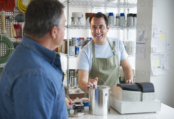 USA, New Jersey, Jersey City, Shop owner and assistant working in paint shop.