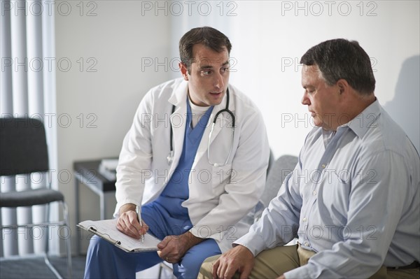 USA, New Jersey, Jersey City, Doctor discussing medical results with male patient in hospital.