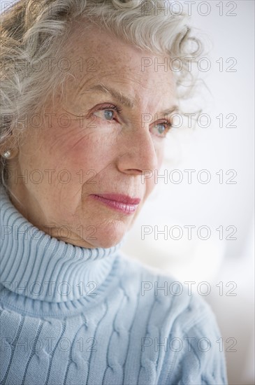 Pensive senior woman smiling.