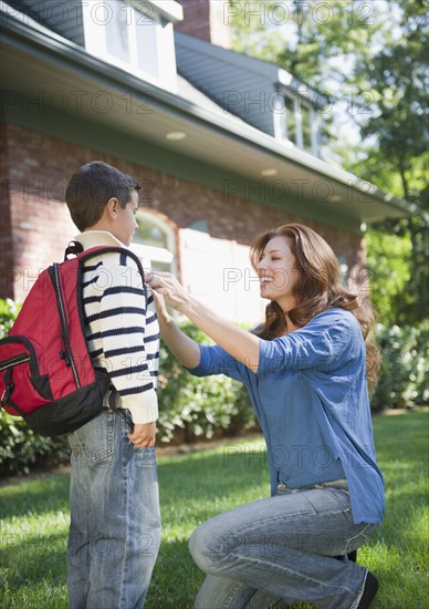 USA, New York, Flanders, Mother assisting boy (8-9) before departure to school. Photo : Jamie Grill Photography