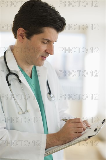 USA, New Jersey, Jersey City, Male doctor writing medical report.