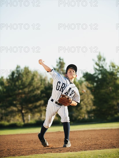 Boy (10-11) playing baseball.