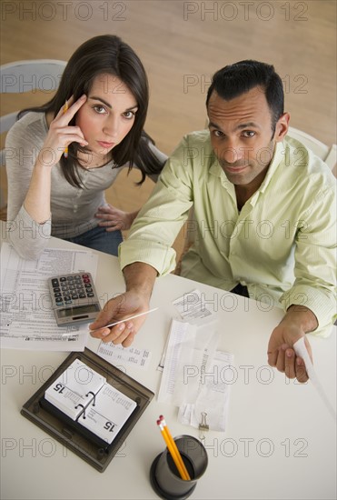 Couple doing taxes and looking at camera.