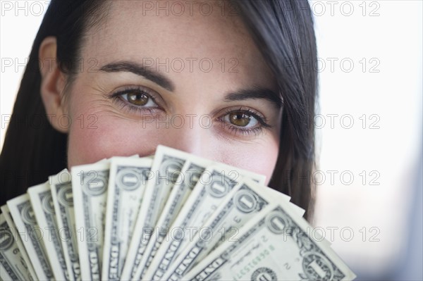 Portrait of young woman with fanned out banknotes.