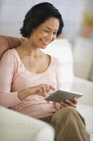 Mixed race woman using digital tablet.
