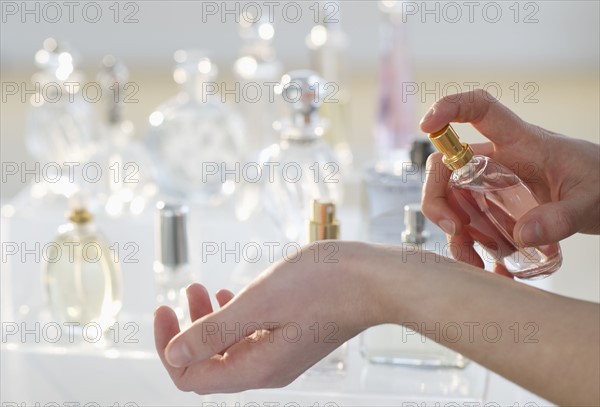 Young woman testing perfume.