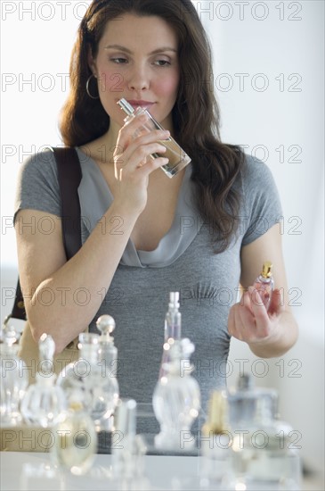 Young woman testing perfume.