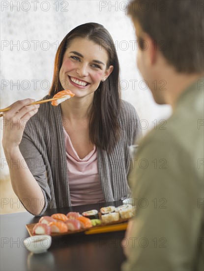 Young couple eating sushi.