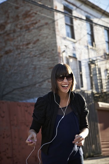 USA, New York City, Brooklyn, woman listening to mp3 player. Photo : Shawn O'Connor