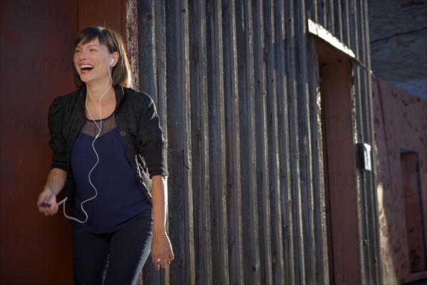 USA, New York City, Brooklyn, woman listening to mp3 player. Photo : Shawn O'Connor