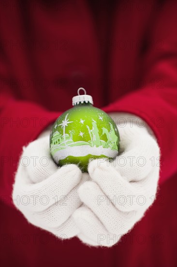 Young woman holding Christmas bauble. Photo : Mike Kemp