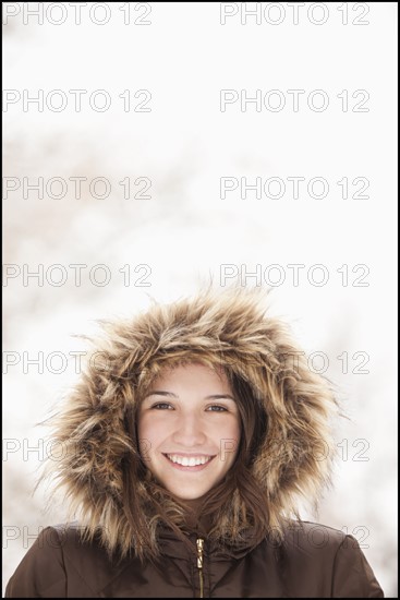 USA, Utah, Lehi, Portrait of young woman wearing fur hooded coat. Photo : Mike Kemp