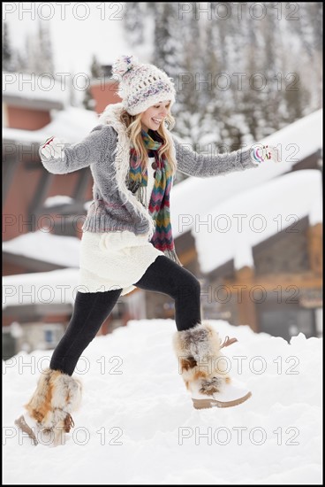 USA, Utah, Salt Lake City, young woman walking through snow in resort. Photo : Mike Kemp