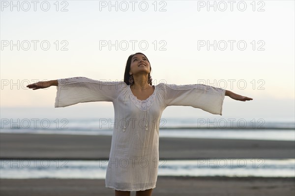 USA, California, Stinson Beach, Young woman with arms up on beach. Photo : Noah Clayton