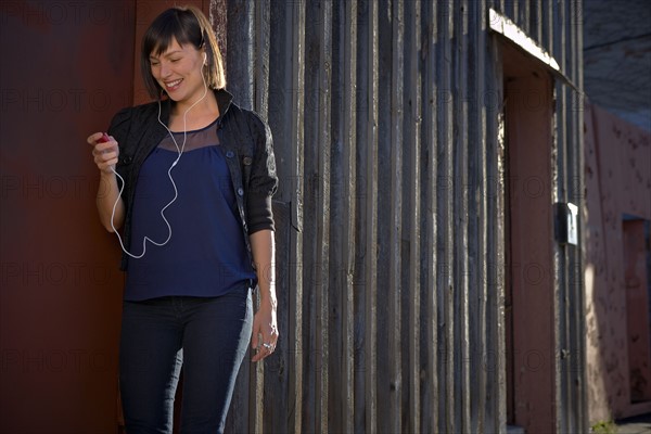 USA, New York City, Brooklyn, woman listening to mp3 player. Photo : Shawn O'Connor