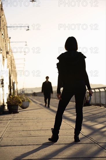 USA, New York City, Brooklyn, woman with bottle standing in street. Photo : Shawn O'Connor